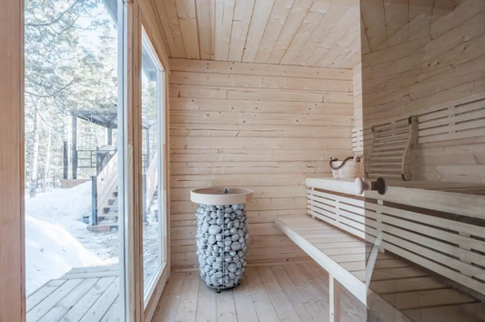 Banco y cubo de piedras en una sala de sauna.