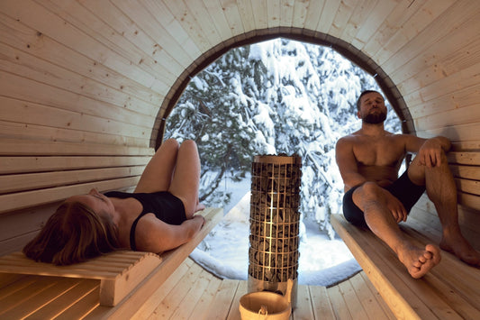 Hombre y mujer relajándose en una sauna al aire libre.