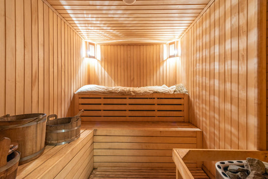 Sauna de madera con banco y cubo.