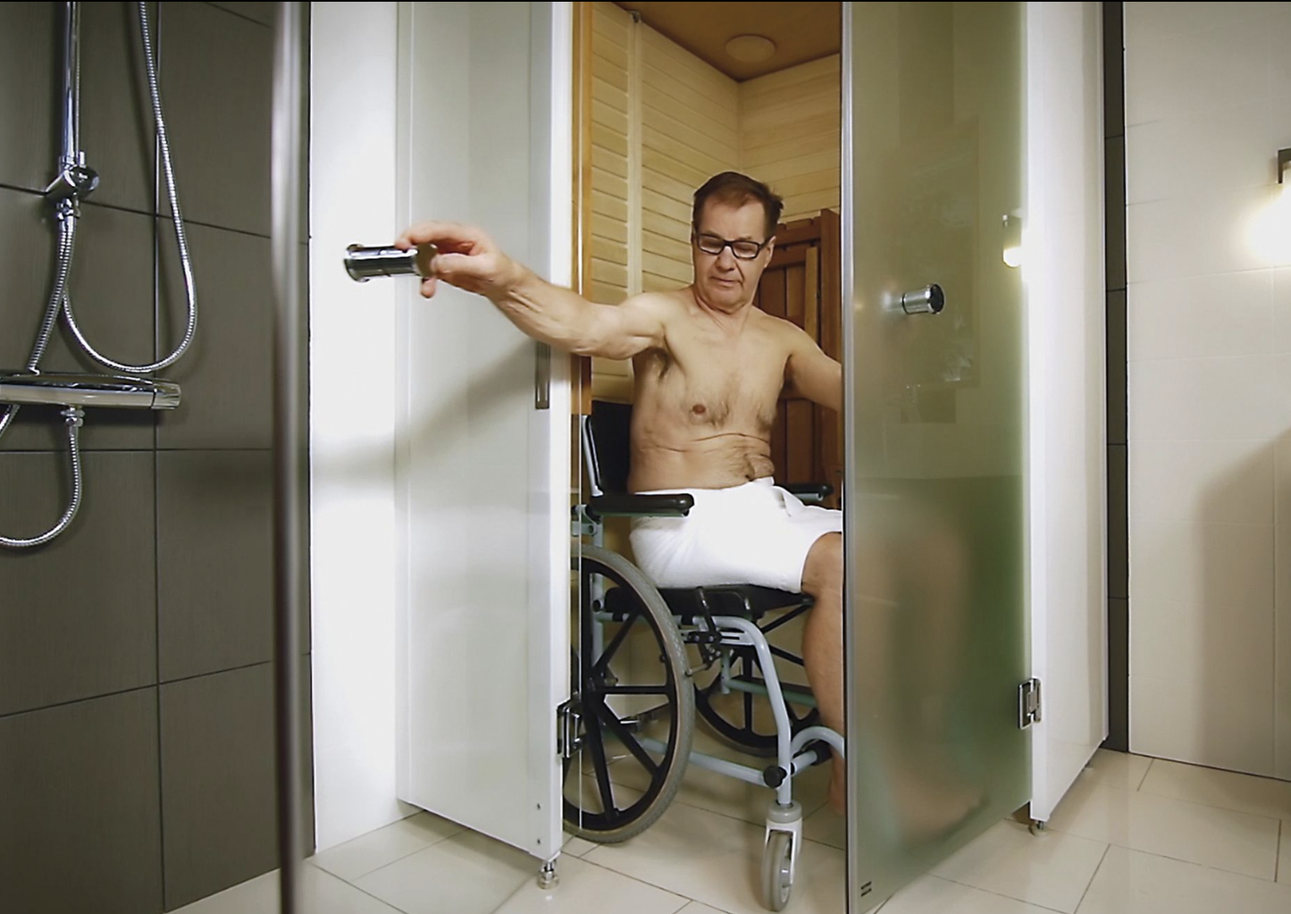 Un hombre en silla de ruedas utilizando la Sauna SmartFold.