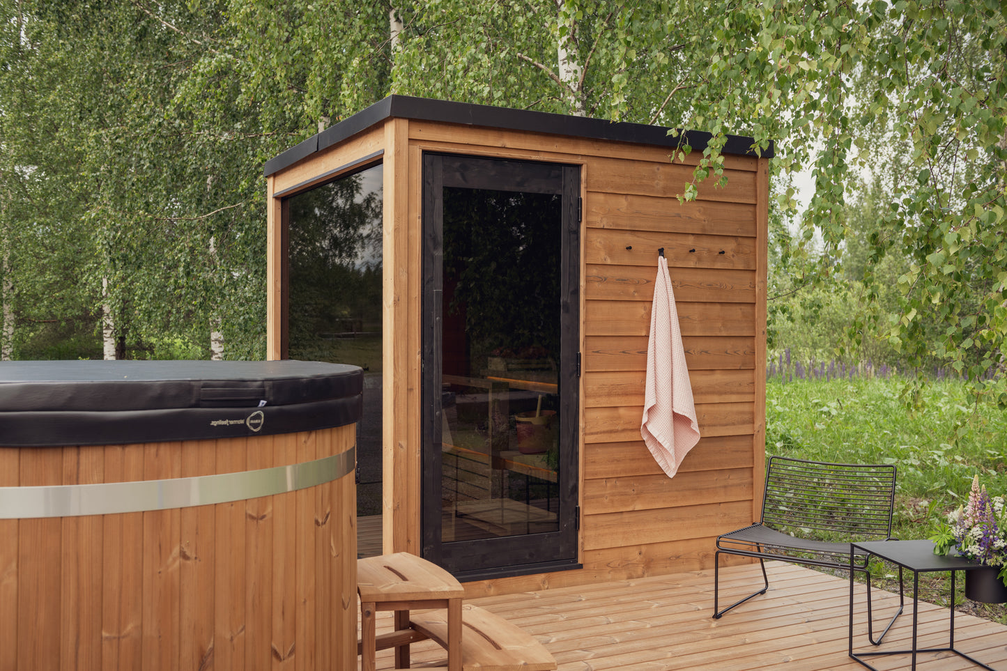 Sauna exterior Nordic Dawn con puerta de cristal y bancos de madera.