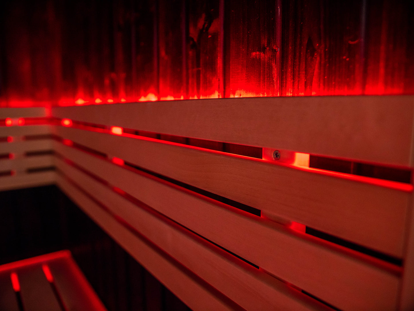 Sauna Fenix con luz LED roja sobre banco de madera.