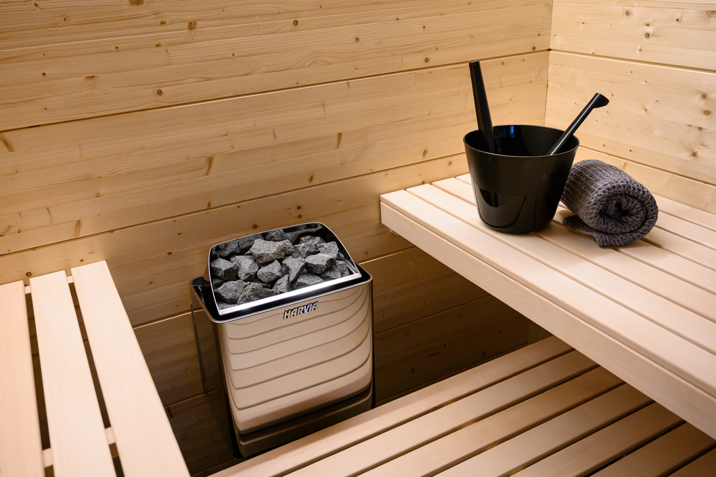 Calentador eléctrico Harvia KIP en sauna con cubo de piedra.