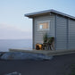 Saunamo Sauna al aire libre Nordica en la playa con silla y planta.